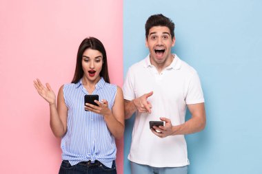 Görüntü heyecanlı insan ve rahat kıyafet cep telefonları renkli arka plan üzerinde izole tutan kadın