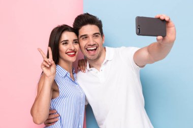 Görüntü olumlu erkek ve kadın üstünde hareket eden telefon renkli arka plan üzerinde izole selfie fotoğraf çekme