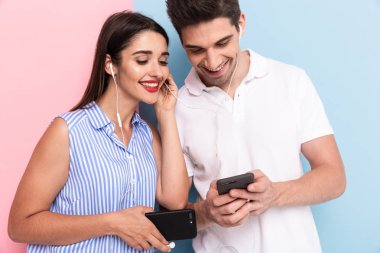 Görüntü esmer erkek ve kulaklık giyen ve renkli arka plan üzerinde izole akıllı telefonlar kullanan kadın