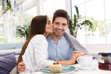 İnanılmaz genç sevgi dolu çift birbirleriyle sarılma kafede oturan.