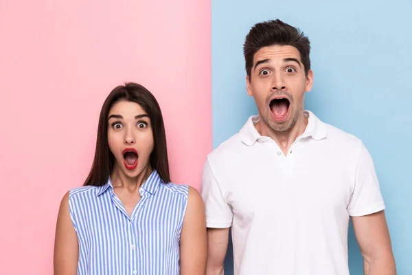 Image of shocked man and woman in casual wear screaming isolated over colorful background