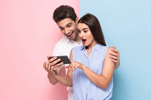 Imagen Pareja Atractiva Años Sonriendo Mirando Teléfono Móvil Aislado Sobre — Foto de Stock