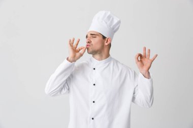 Görüntü izole kapalı beyaz duvar arka plan üzerinde yakışıklı genç şef.