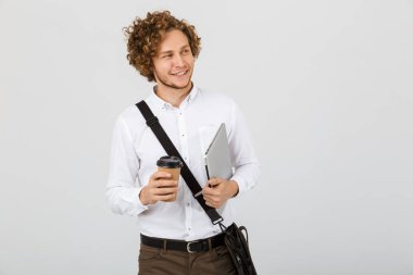 Kahve fincanı ve laptop holding beyaz arka plan üzerinde izole gömlek giymiş gülümseyen bir işadamı portresi