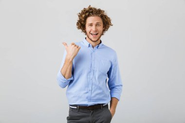 Neşeli bir genç adam uzakta parmak işaret kıvırcık saçlı beyaz arka plan üzerinde izole portresi