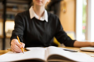 Bir ders kitabı yazma Kitaplığı ' nda masada okuyan bir genç kızın yakın çekim