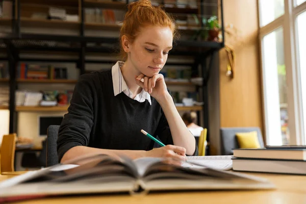 Piękne Czerwone Włosy Dziewczyna Nastoletnich Studia Przy Stole Bibliotece — Zdjęcie stockowe