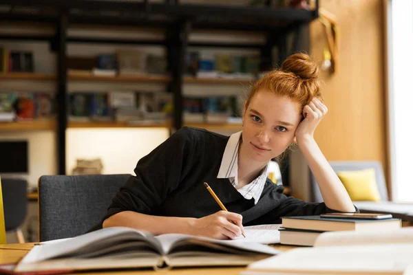 Imagen Hermosa Pelirroja Feliz Estudiante Sentada Mesa Con Libros Biblioteca —  Fotos de Stock