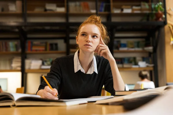 Koncentrált Vörös Hajú Tizenéves Lány Tanul Asztalnál Könyvtár — Stock Fotó