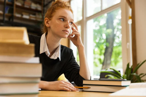 Skoncentrowane Rudowłosy Dziewczyna Nastoletnich Studia Przy Stole Bibliotece — Zdjęcie stockowe