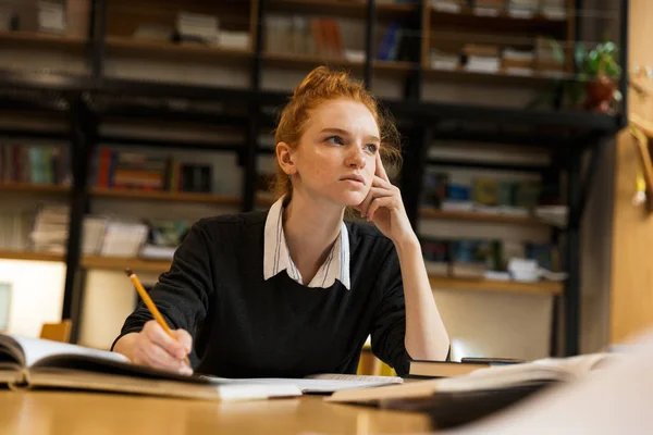 Grave Menina Adolescente Ruiva Estudando Mesa Biblioteca — Fotografia de Stock