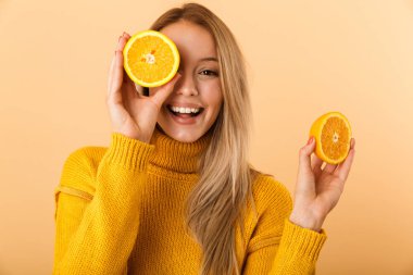 Sarı duvar arka plan üzerinde izole gözlerle narenciye limon poz kapsayan bir güzel kadın fotoğrafı.