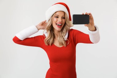 Mutlu sarışın bir kadın portresi bir selfie alarak, beyaz arka plan üzerinde izole duran kırmızı yılbaşı kostüm giymiş
