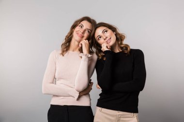 Görüntü, gri arka plan üzerinde gülümseyen ve birlikte poz izole iki genç kız