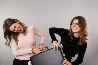 Görüntü gri arka plan üzerinde izole dolar para ile diplomat için mücadele iki beyaz kız