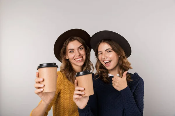 Imagen Dos Mujeres Jóvenes Con Sombreros Sosteniendo Café Para Llevar —  Fotos de Stock