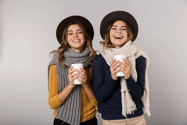 Immagine Due Donne Allegre Che Indossano Cappelli Sciarpe Che Bevono — Foto Stock