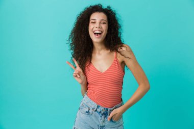 Görüntü üzerinde mavi arka plan izole ayakta gülüyor neşeli kadın 20'li yaşlarda giyiyor rahat giyim
