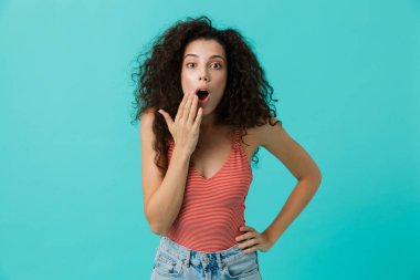 Çığlık, üzerinde mavi arka plan ayakta izole şok kadın 20'li yaşlarda giyiyor rahat giyim görüntü