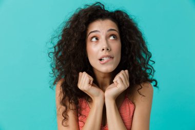 Görüntü güzel kadın 20'li yaşlarda giyiyor rahat giyim üzerinde mavi arka plan izole ayakta gülüyor