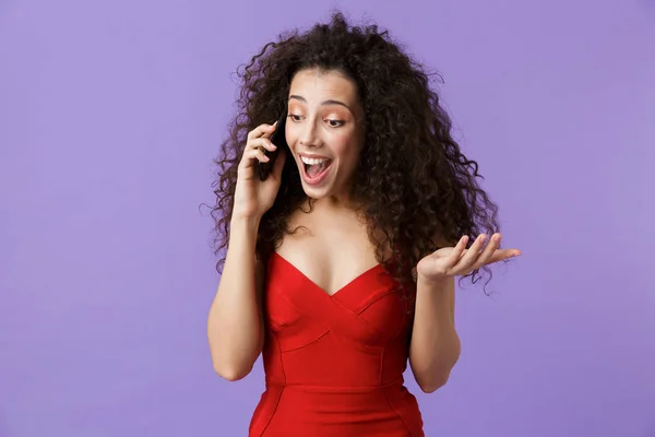 穿着红色礼服的美女20多岁的形象在黑色智能手机上说话 站在紫罗兰色背景上被孤立 — 图库照片