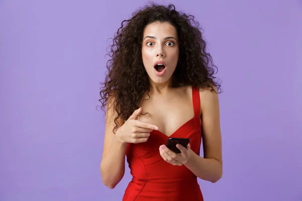 Imagen Mujer Sorprendida Años Usando Vestido Rojo Sosteniendo Teléfono Inteligente —  Fotos de Stock