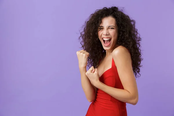 一个快乐的女人的肖像与深色卷发穿着红色礼服隔离在紫罗兰色背景 庆祝成功 — 图库照片