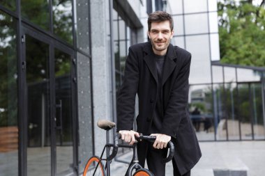 Açık havada bisiklet ile yürüyüş yakışıklı genç iş adamı görüntüsü.