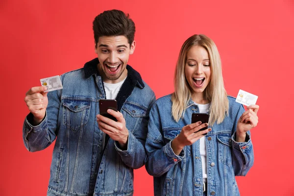 Porträt Eines Aufgeregten Jungen Paares Jeansjacken Das Isoliert Vor Rotem — Stockfoto