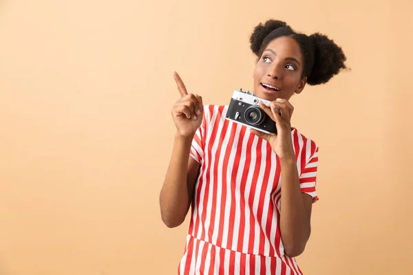 うれしそうなアフリカ系アメリカ人女性笑顔と ベージュの背景の上分離されたレトロなカメラで撮影 — ストック写真