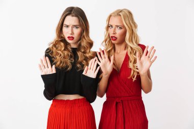 Çığlık makyaj ayakta beyaz arka plan üzerinde izole giyen iki kızgın genç akıllıca giyimli kadın portresi