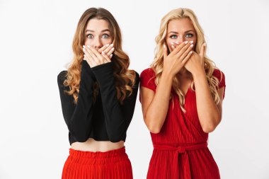 İki şok genç akıllıca giyimli kadın makyaj ayakta beyaz arka plan, kollu kapak yüz üzerinden izole giyen portresi