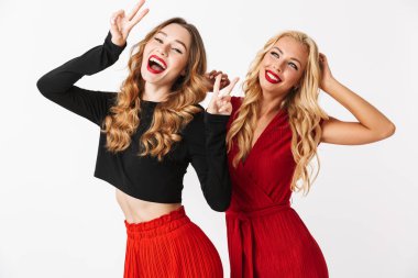 İki neşeli genç akıllıca giyimli kadın makyaj ayakta beyaz arka plan üzerinde izole giyen portresi kutluyor