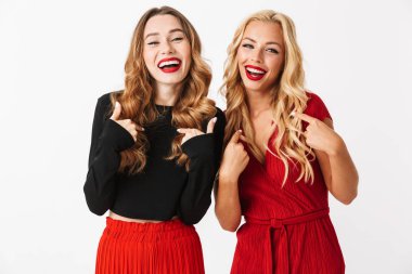 İki neşeli genç akıllıca giyimli kadın makyaj ayakta beyaz arka plan üzerinde izole giyen portresi işaret