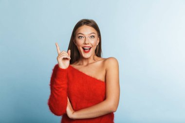 Boşaltmak gösterilen mavi duvar arka plan üzerinde izole poz bir güzel şirin şaşırtıcı genç kadın imajını bir fikir var.