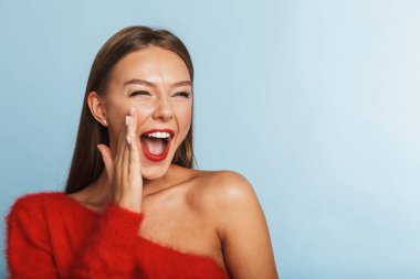 Görüntü izole mavi duvar arka plan üzerinde poz güzel duygusal çığlık atan genç bir kadın.