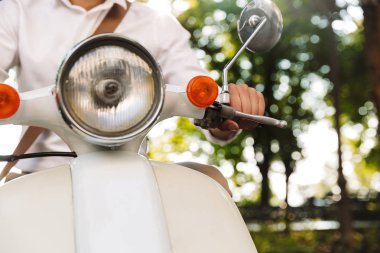 Açık havada bir motosiklet üzerinde oturan genç işadamı resim kırpılmış