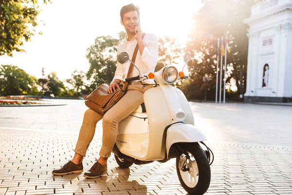 Glimlachend Jonge Zakenman Zittend Een Motorfiets Buitenshuis Praten Mobiele Telefoon — Stockfoto