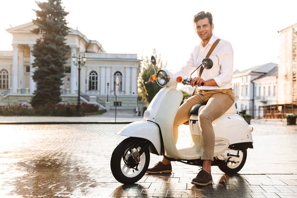 スクーターで野外を歩いているハンサムな若いビジネスマンのイメージ — ストック写真
