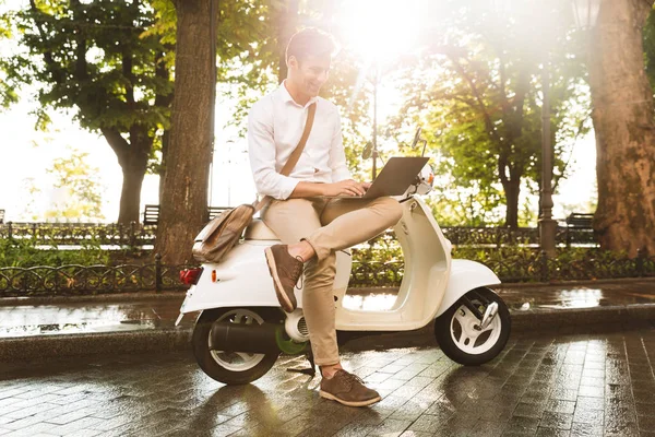 Веселый Молодой Бизнесмен Сидящий Мотоцикле Открытом Воздухе Работающий Ноутбуком — стоковое фото