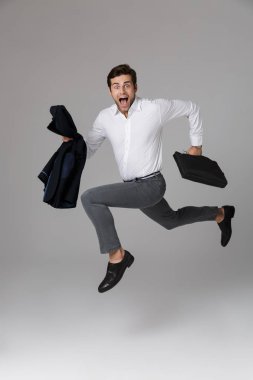 Tam boy görüntü office adamın 30'lu çanta ve ceket gri arka plan üzerinde izole elinde ile çalışan takım elbise
