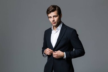 Kendine güvenen işadamı 30'lu kameraya seyir siyah ceketli görüntü gri arka plan izole