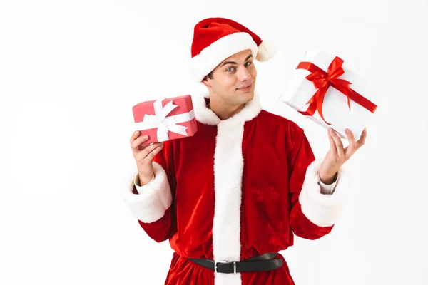 亲切的人30多岁的肖像在圣诞老人服装和红色帽子举行礼物箱子查出在白色背景在演播室 — 图库照片