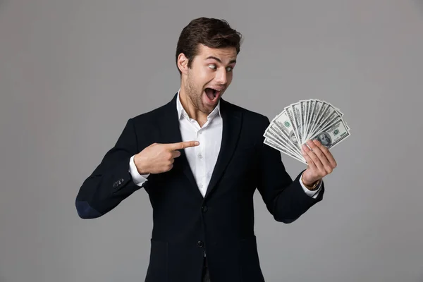 ブルネット ビジネスマン 代スーツ笑顔と灰色の背景上分離されたドル紙幣でお金のファンを保持しているのイメージ — ストック写真