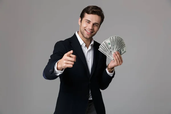 笑顔と灰色の背景上分離されたドル紙幣でお金のファンを保持のスーツで成功した実業家の 代のイメージ — ストック写真
