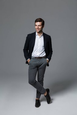 Görüntü arka plan gri duvar poz içinde izole bir yakışıklı genç iş adamı.