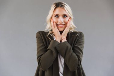 Görüntüsünü ceket giyen kadın 20'li yaşlarda merak şaşırttı ve yüz dokunmadan gri arka plan üzerinde izole