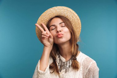 Şirin güzel bir kadın barış hareketi izole mavi duvar arka plan üzerinde gösterilen görüntü.