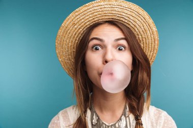 Mutlu bir güzel kadının poz görüntü üzerinde mavi duvar arka plan ciklet ile izole.