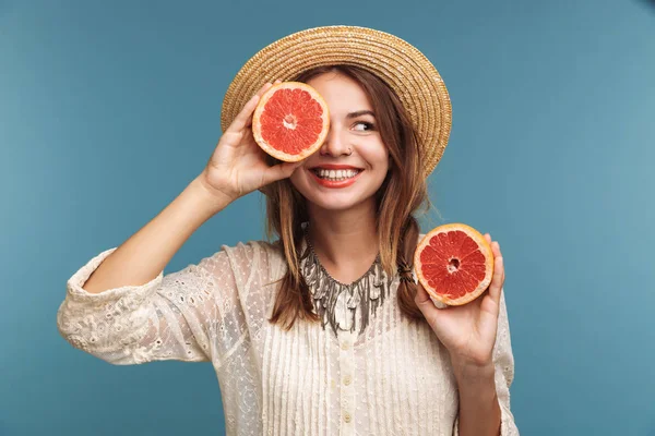 一个快乐的漂亮的女人的形象提出隔离在蓝色墙壁背景与橙色柑橘 — 图库照片